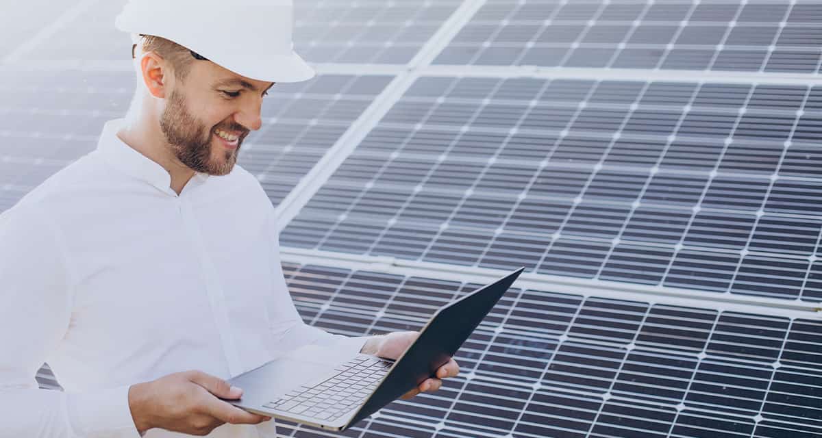 architect standing by solar panels making diagnostics computer