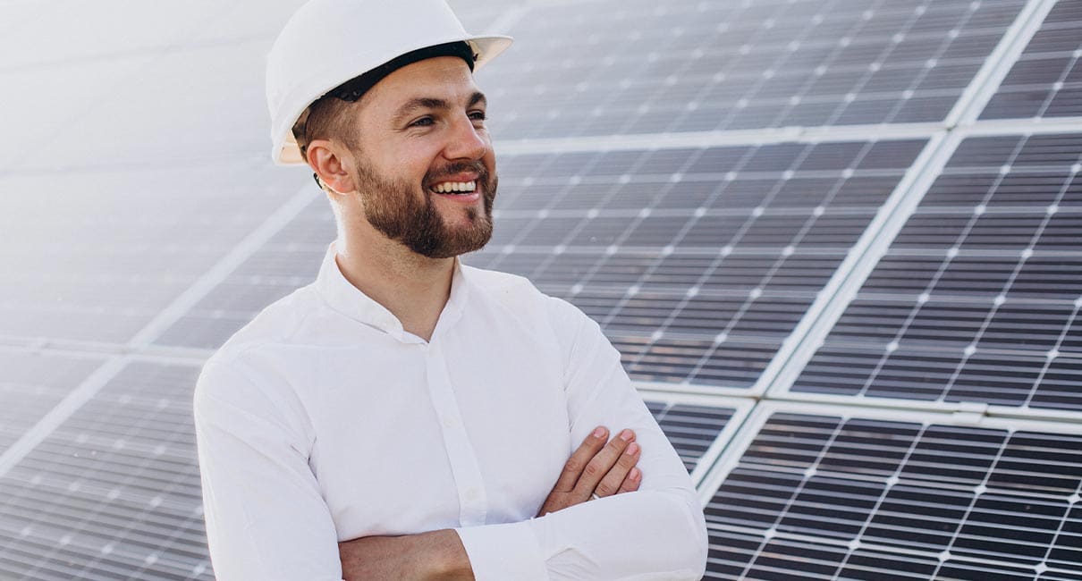 man happy standing by solar panels