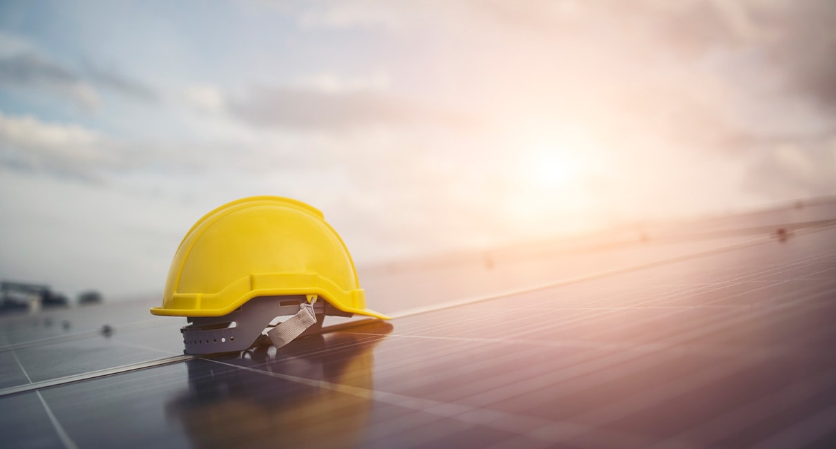 construction yellow hat on top of a solar panel